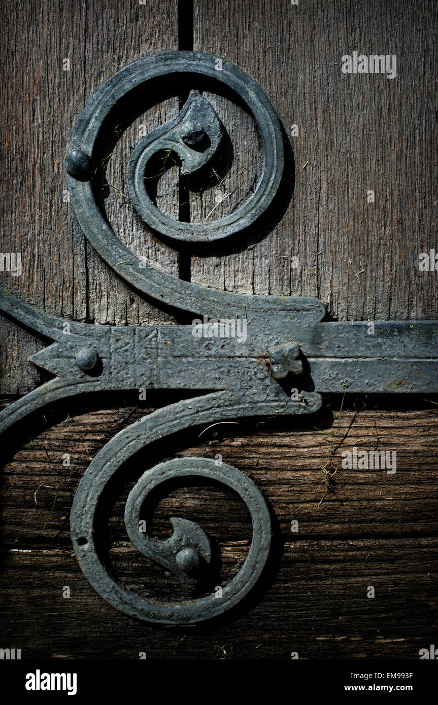 Molto vecchio fabbro, fatta a mano in ferro metallico cerniera su legno porta in legno di quercia. Foto Stock