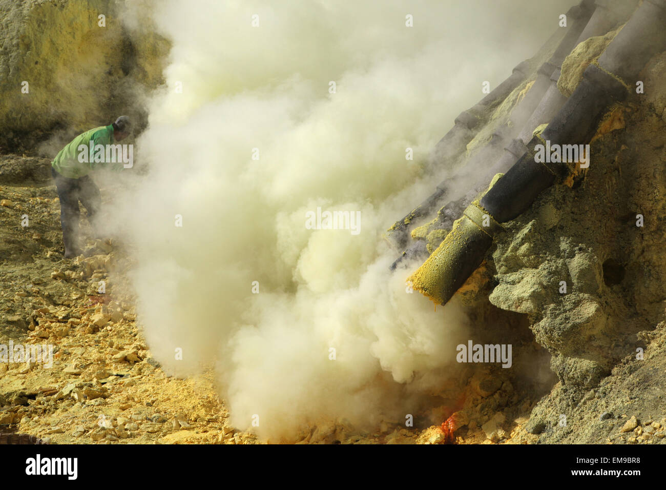 Miniere di zolfo Kawah Ijen, Java Orientale, Indonesia. Il minatore raccoglie zolfo nei fumi tossici i gas vulcanici nel cratere del vulcano. Foto Stock