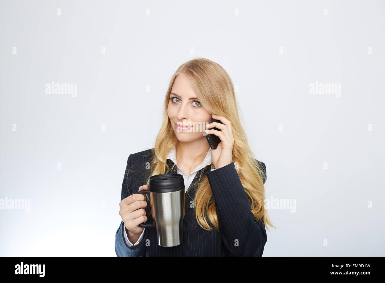 Bella imprenditrice caucasici di parlare al telefono tenendo un caffè Foto Stock