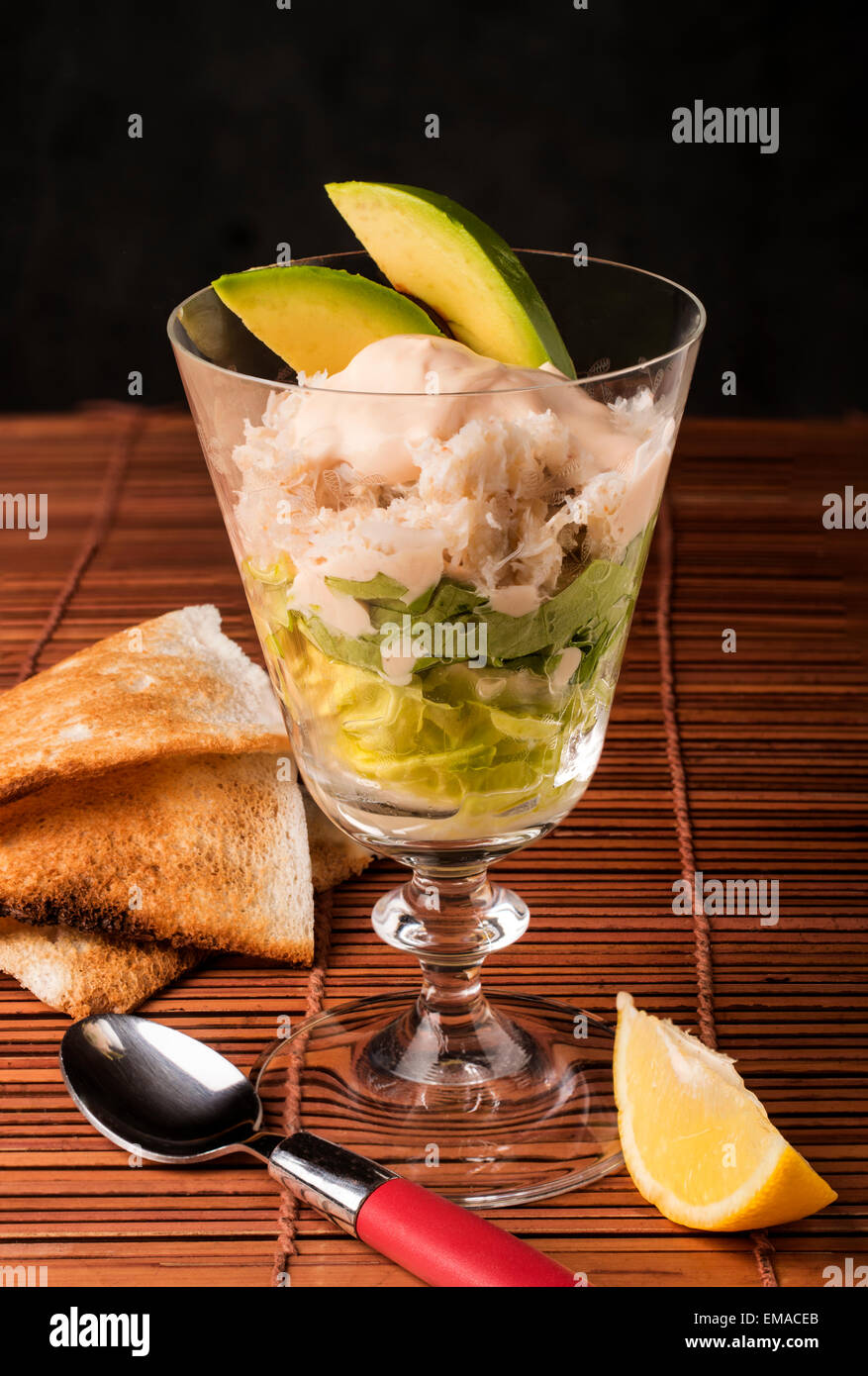 Polpa di granchio cocktail insalata con fette biscottate - insalata di avocado e granchio marie-rose salsa con una fettina di limone Foto Stock