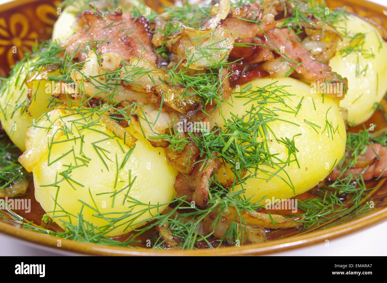 Patate bollite con pancetta fritta ed erbe aromatiche Foto Stock