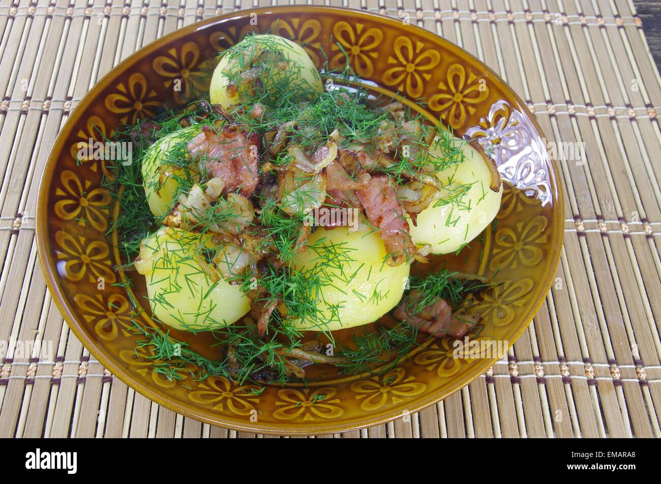 Patate bollite con pancetta fritta ed erbe aromatiche Foto Stock