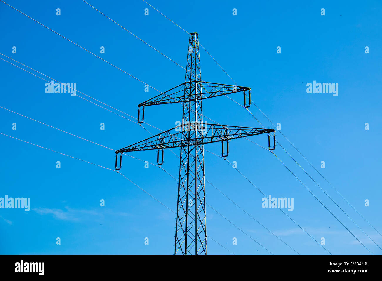Montante Powerline in un campo di fromt di un cielo blu Foto Stock