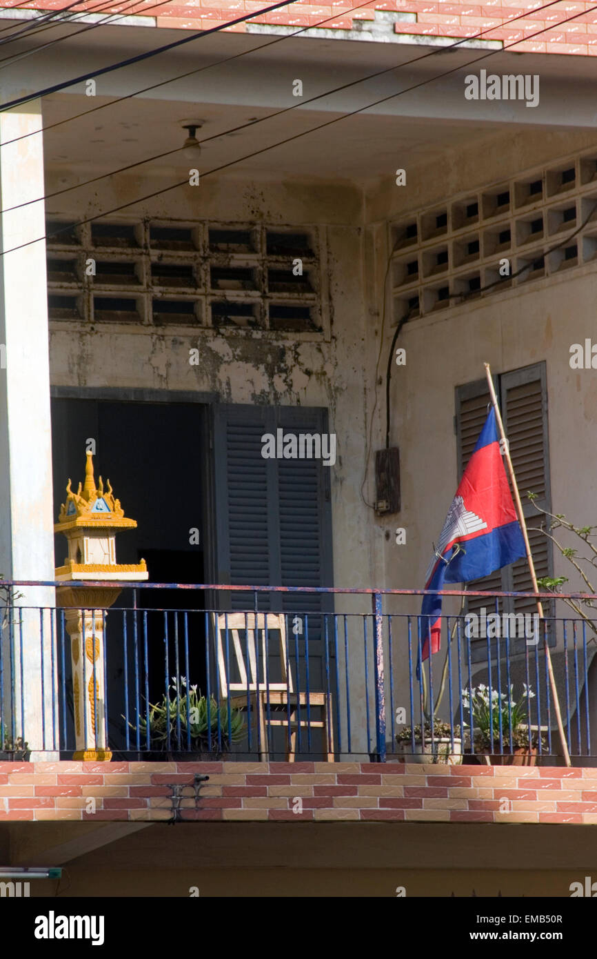 Un Buddista spirito house & un cambogiano di bandiera sono visualizzati sul balcone di una tipica centrale superiore home in Kampong Cham, Cambogia Foto Stock