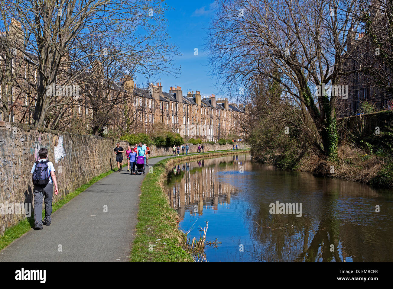 I camminatori e corridori godendo il sole primaverile sul Union Canal vicino Fountainbridge, Edimburgo, Scozia, Regno Unito. Foto Stock