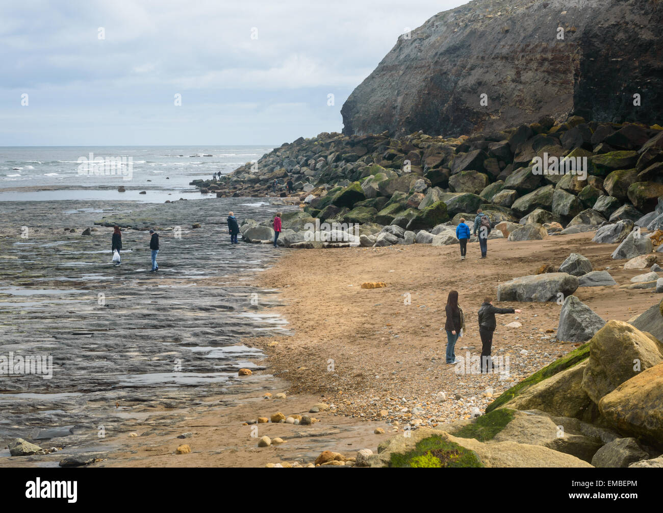 Famiglie beachcombing sulla spiaggia a Whitby, North Yorkshire, Inghilterra. Il 18 aprile 2015. Foto Stock