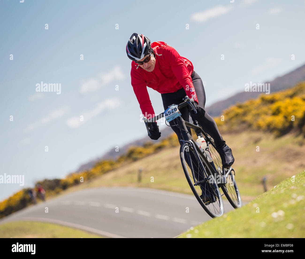 Un maschio ciclista compete nella nuova foresta dimenare evento sportivo su una soleggiata domenica di primavera Foto Stock