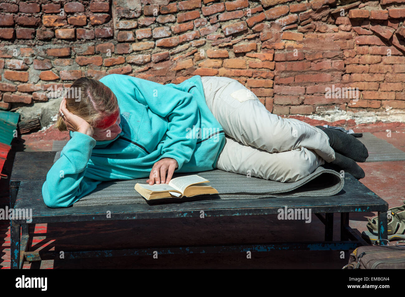 Un turista è la lettura di un libro mentre avente il sole Foto Stock