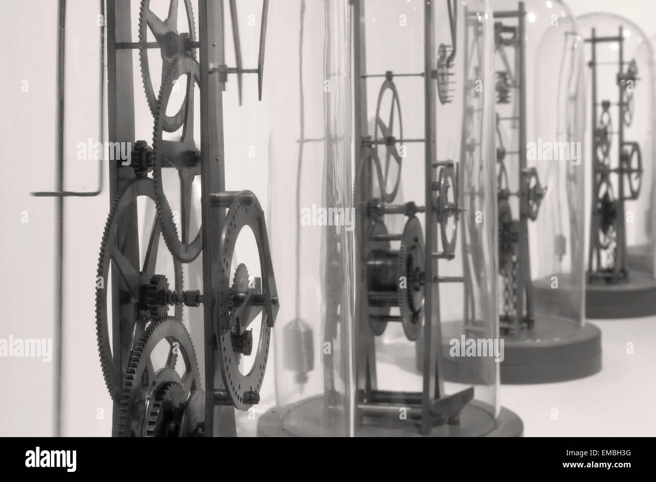 Ingranaggi e quadranti di orologio funziona sotto vetro reso in bianco e nero. Foto Stock