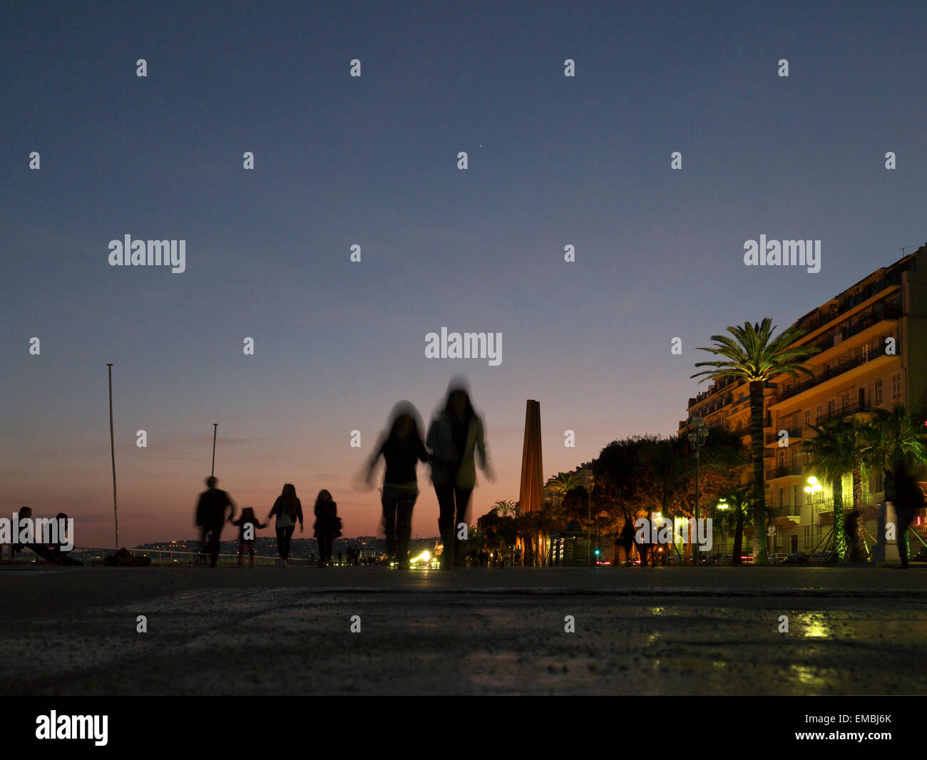 Persone che passeggiano lungo la bella passeggiata al crepuscolo Foto Stock
