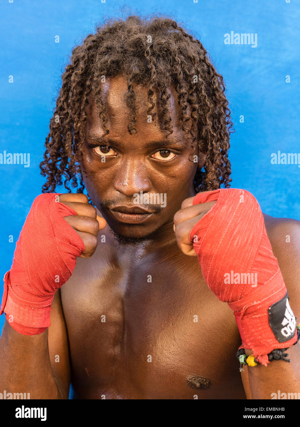 Close-up verticale di un pugile afro-cubane tenendo la sua rosso avvolto a suon di pugni fino durante una sessione presso il Rafael Trejo Boxing palestra. Foto Stock