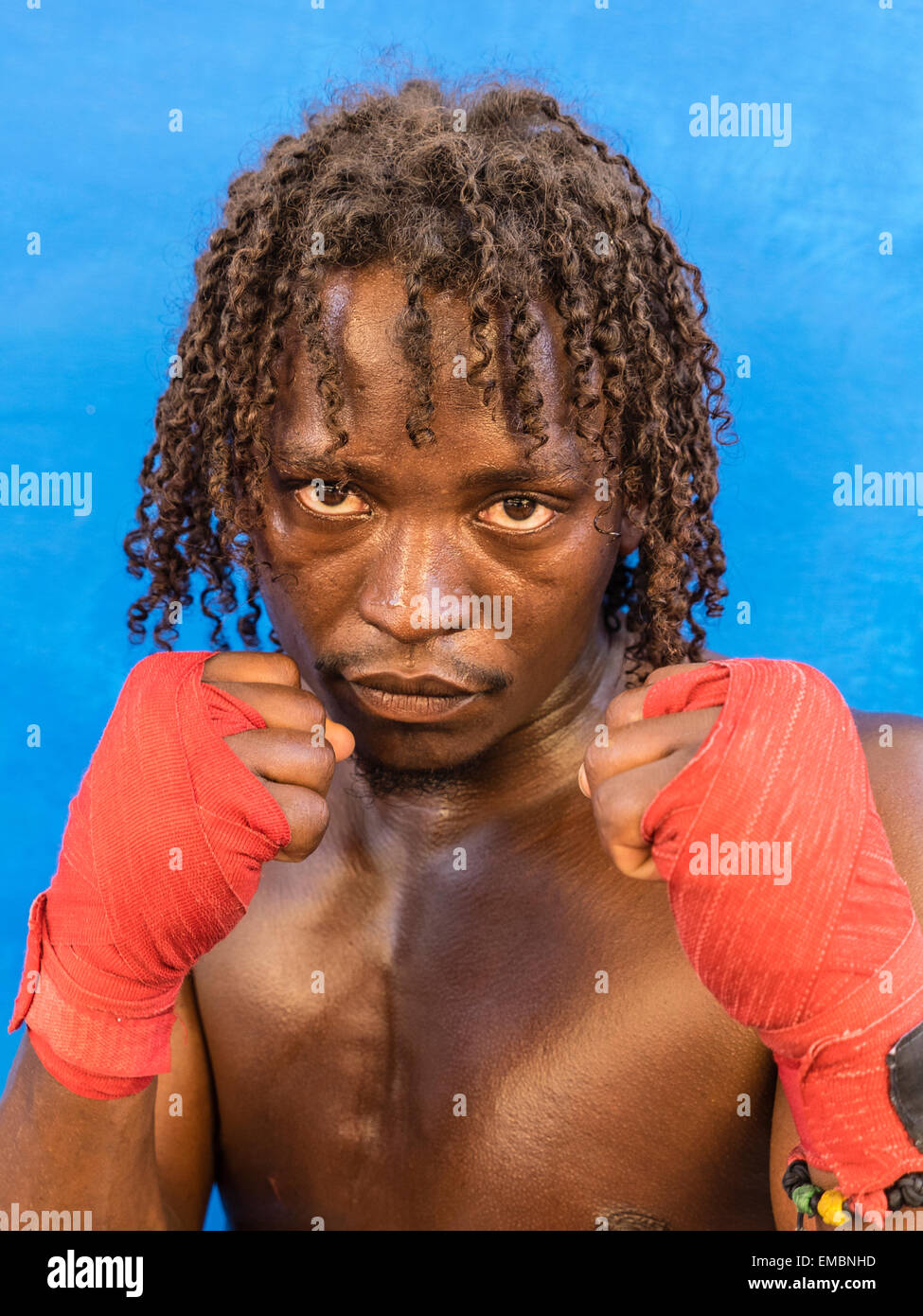 Close-up verticale di un pugile afro-cubane tenendo la sua rosso avvolto a suon di pugni fino durante una sessione presso il Rafael Trejo Boxing palestra. Foto Stock