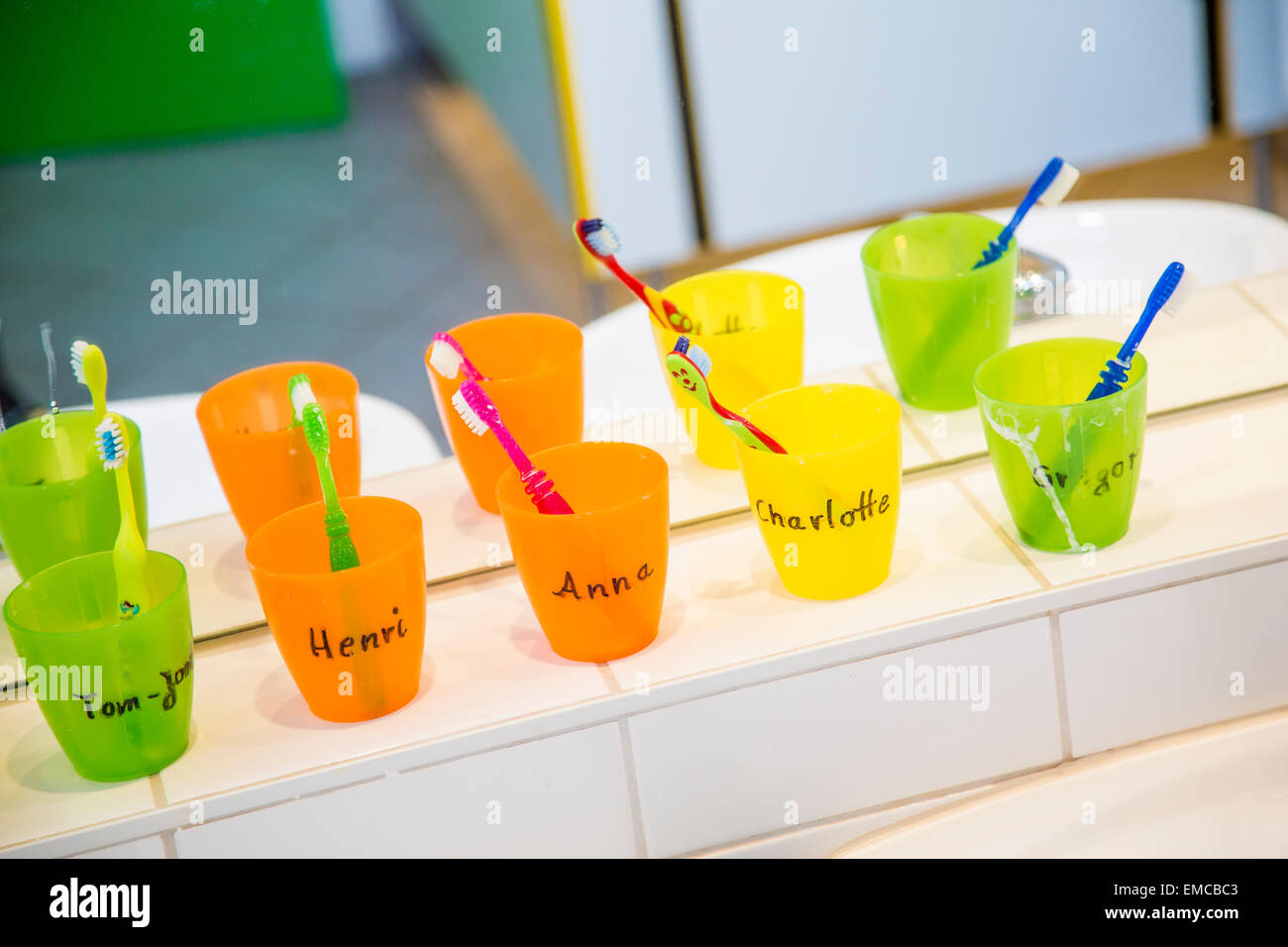 Bicchieri di plastica con gli spazzolini da denti con manes di bambini  negli asili Foto stock - Alamy
