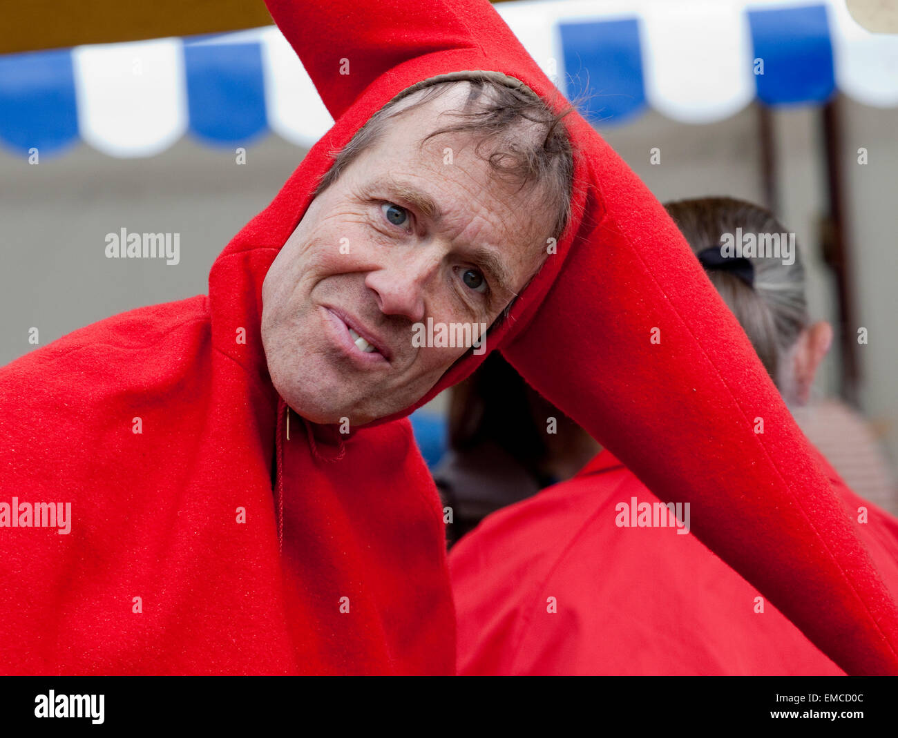 Jester in un ridicolo costume rosso guarda la telecamera Foto Stock