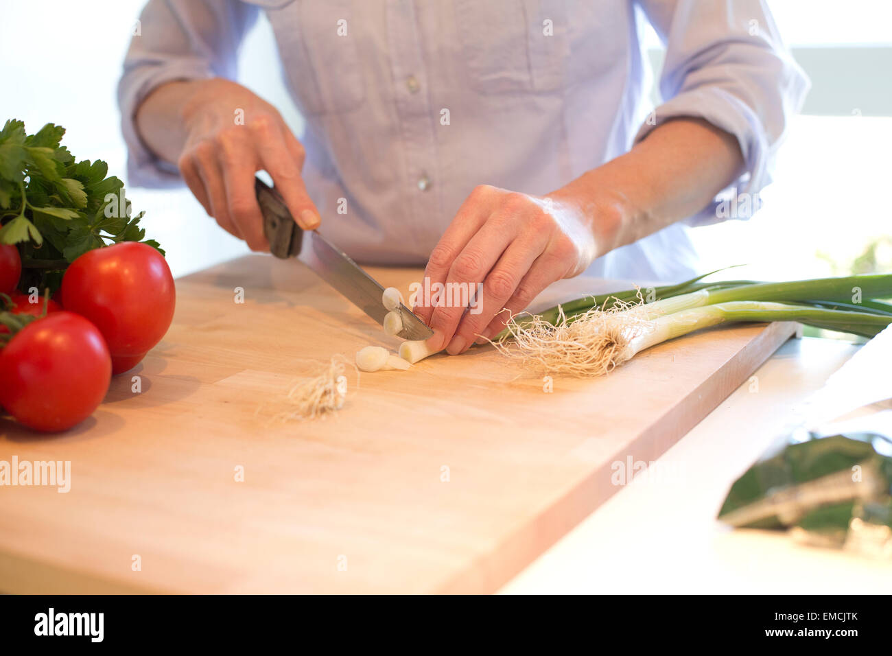 Close-up della donna come tagliare le verdure in cucina Foto Stock
