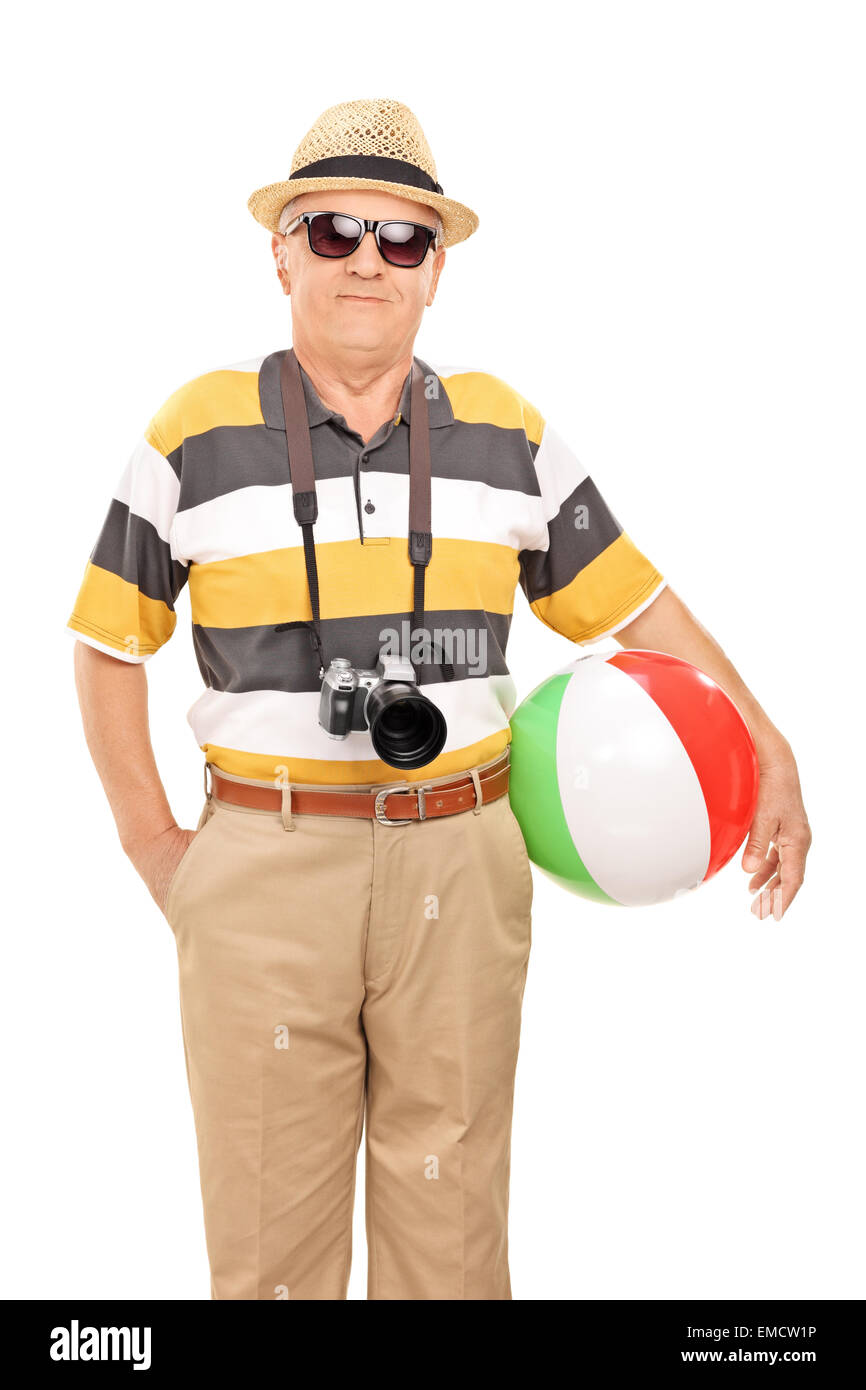 Colpo verticale di una matura turista con occhiali da sole e una macchina fotografica tenendo una palla spiaggia isolata su sfondo bianco Foto Stock