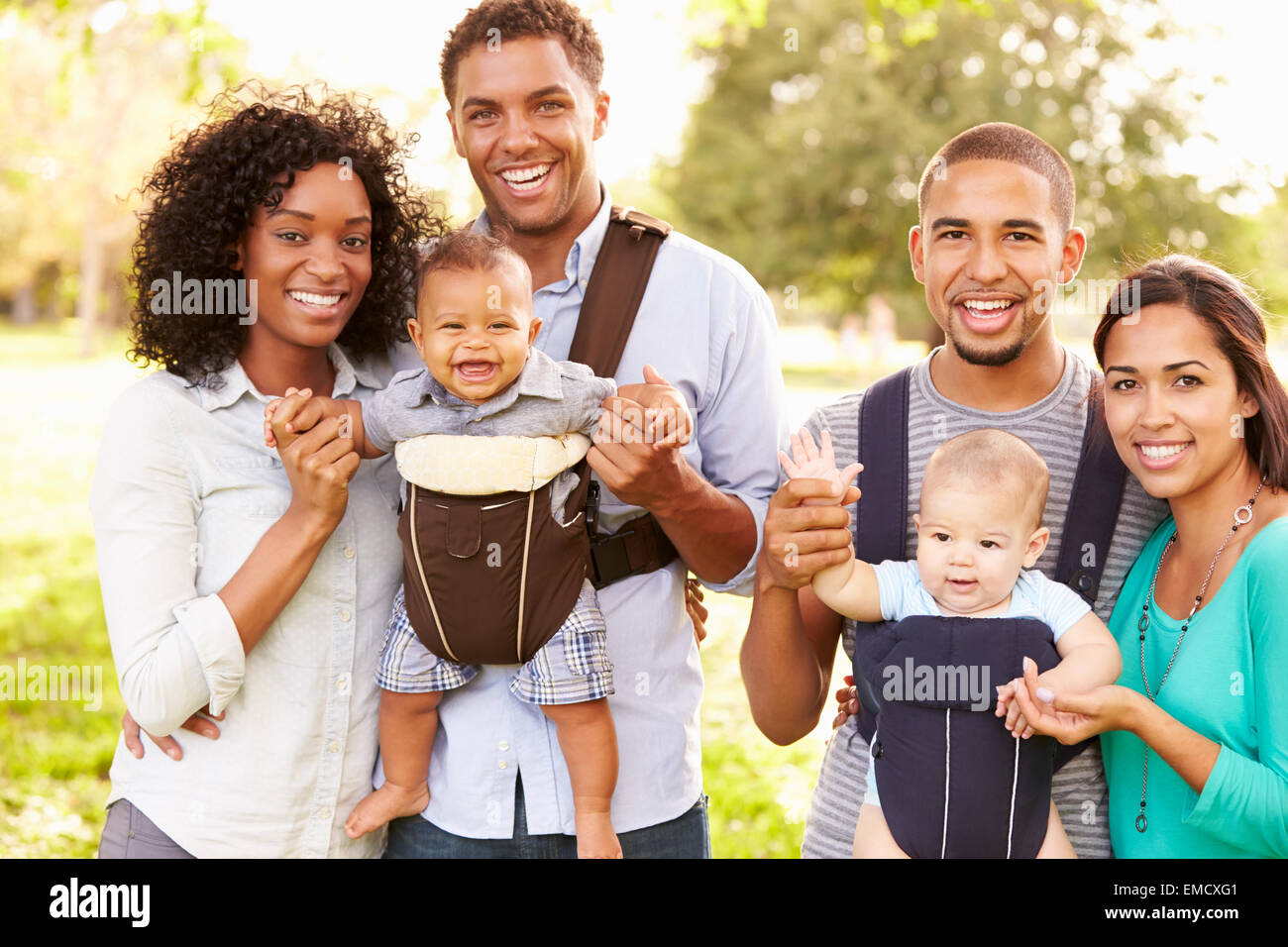Ritratto di due famiglie con Baby Carrier In Park Foto Stock