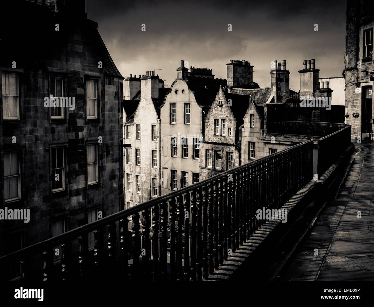 Immagine in bianco e nero di un antica strada di Edimburgo sotto un cielo tempestoso Foto Stock