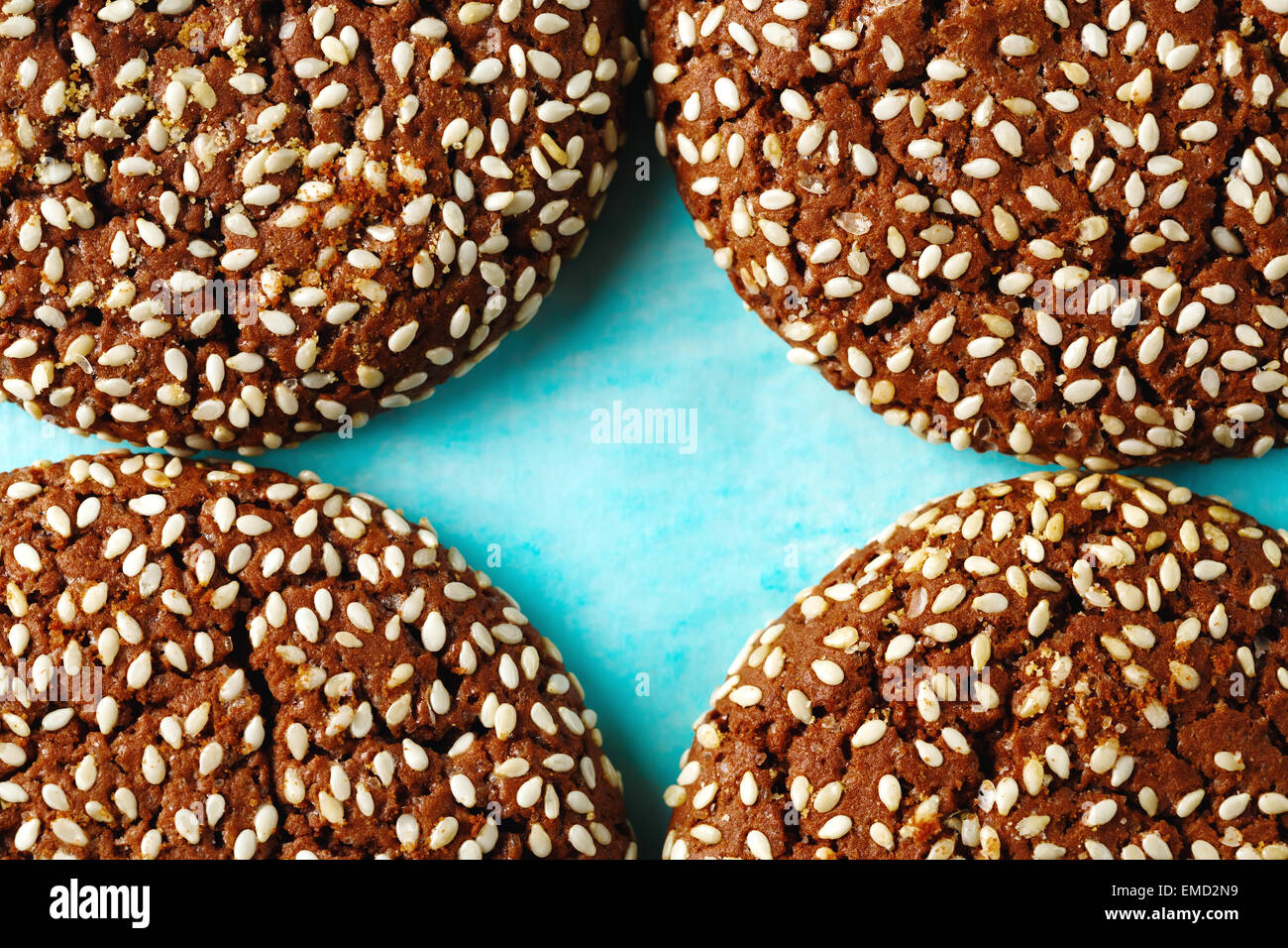 Sfondo di cibo con Cookie pezzi con Sesamo incrinato su due metà su sfondo blu. Macro shot. Spazio per il testo. Foto Stock