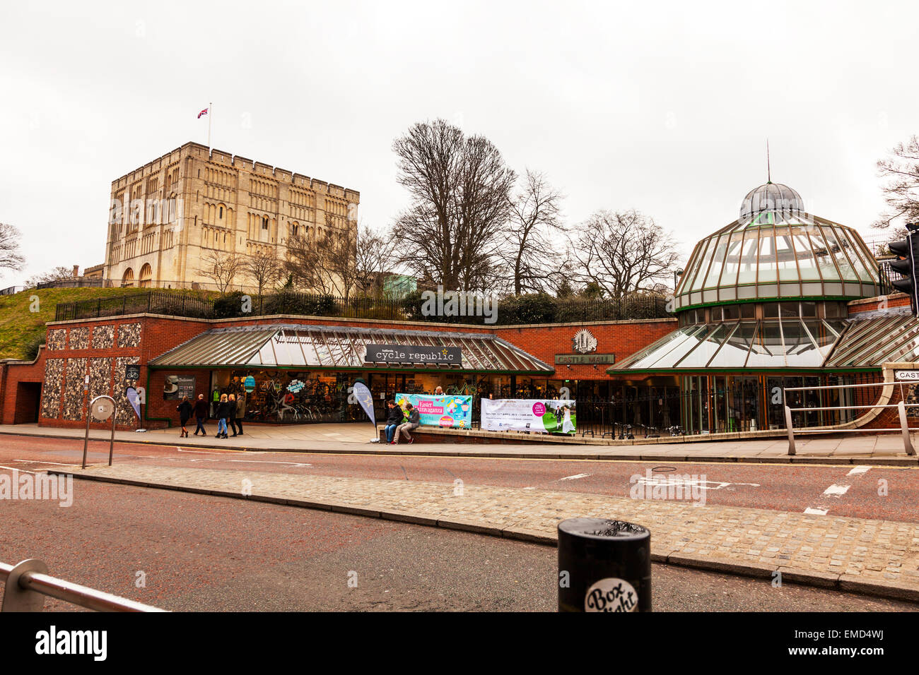 Norwich Castle la costruzione di muri esterni facciata cielo drammatico battenti bandiera NORFOLK REGNO UNITO Inghilterra strada sotto negozi città di percorso Foto Stock