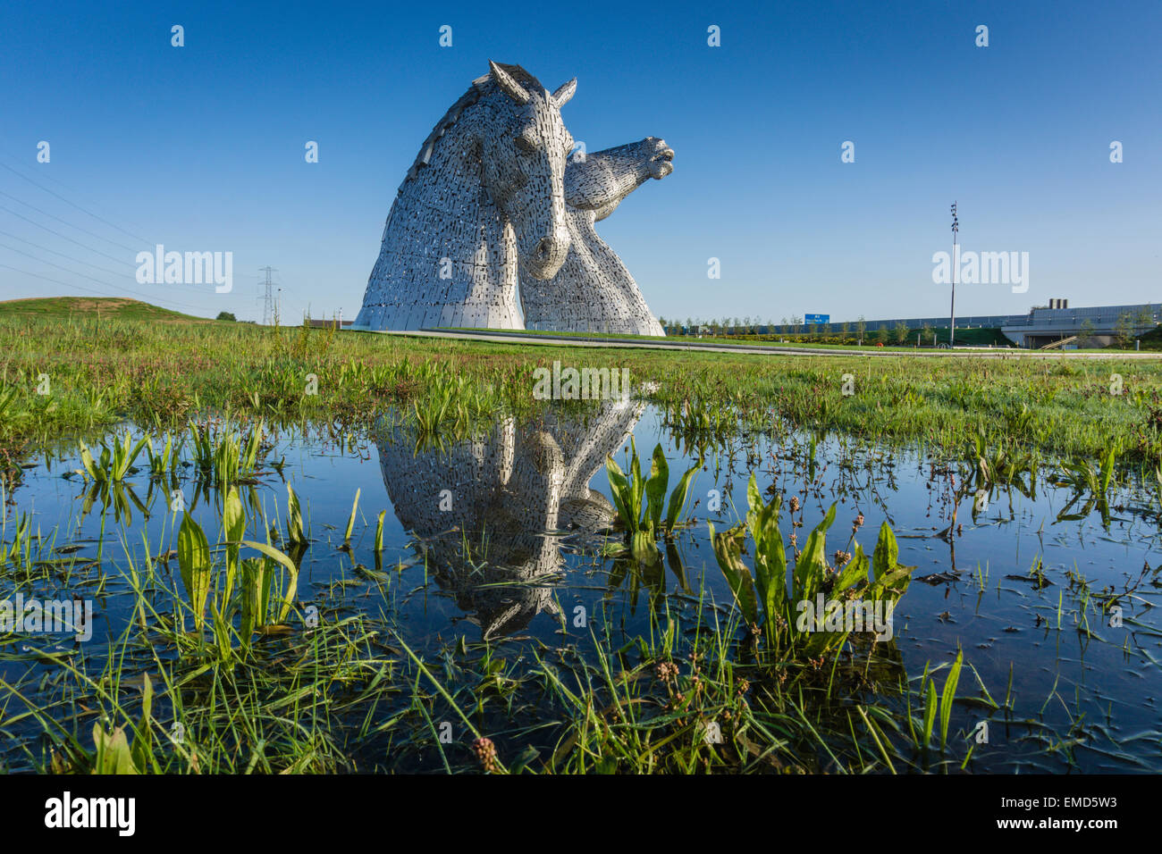 Diurno drammatico colpo di Keplies statue in Falkirk, Scotland, Regno Unito riflessa in acqua nelle vicinanze Foto Stock