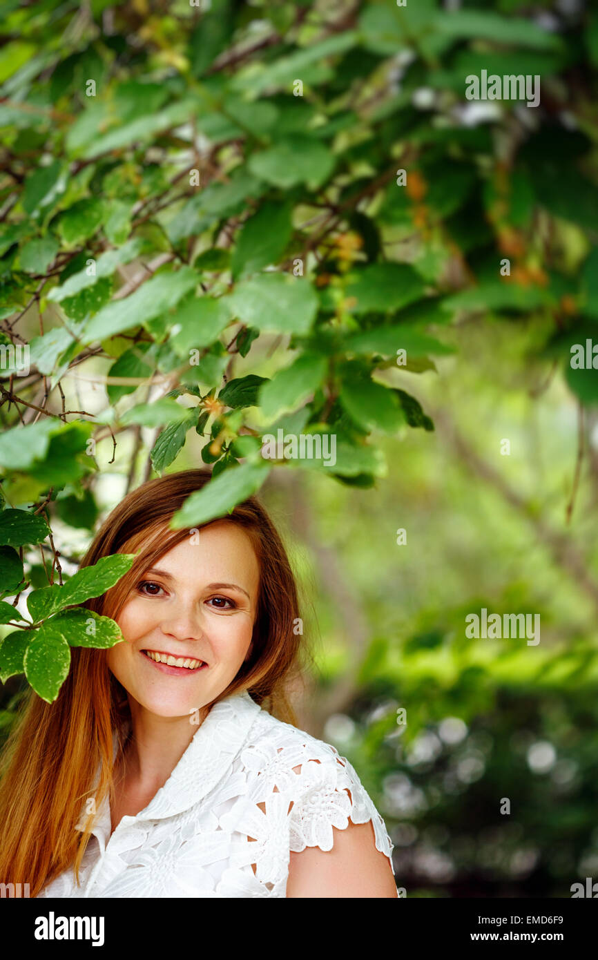 Bellissimi capelli rossi Donna sorridente contro la natura sfondo verde. Estate relax. Foto Stock