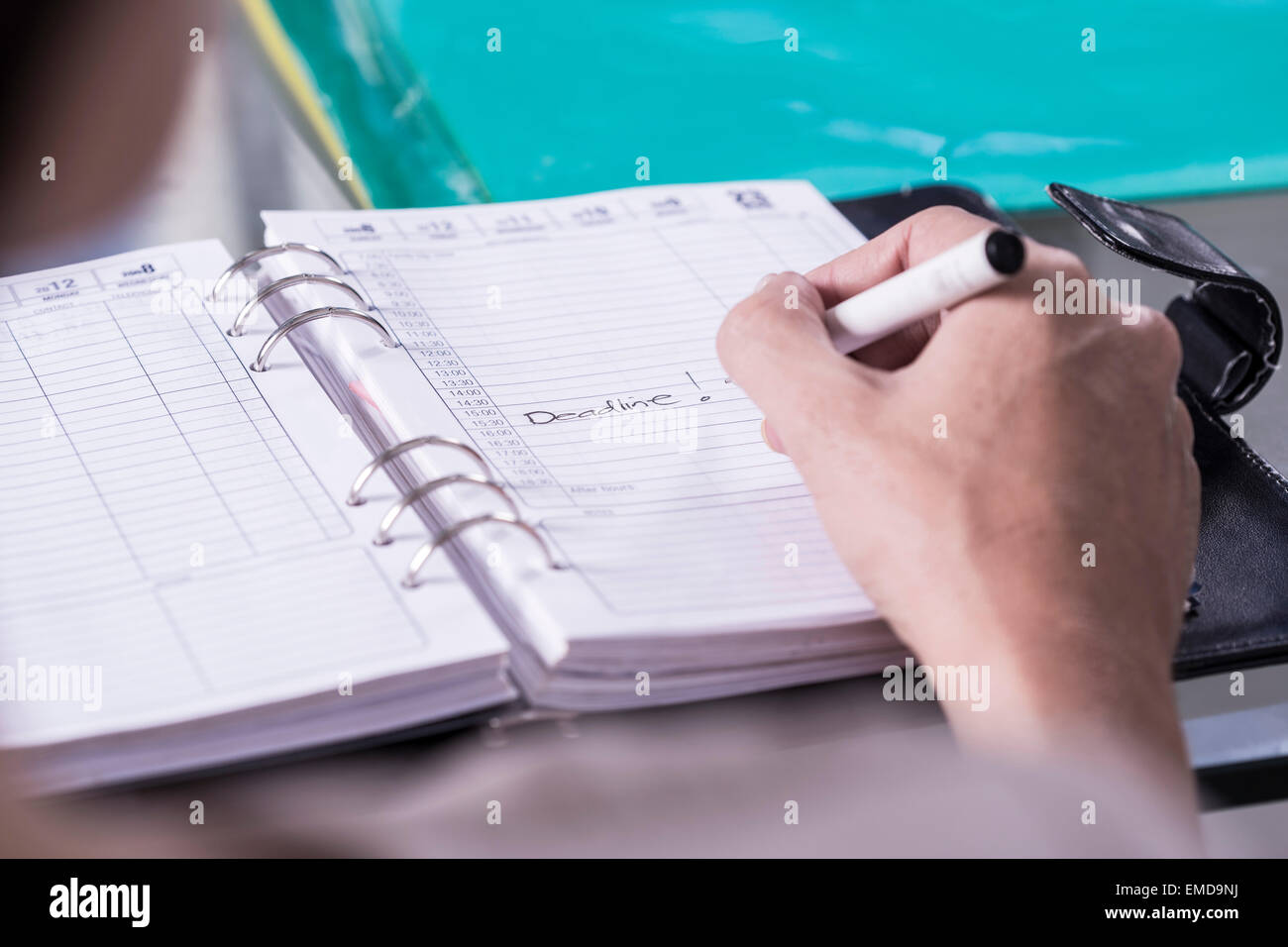 Donna annotando la data in giorno planner Foto Stock