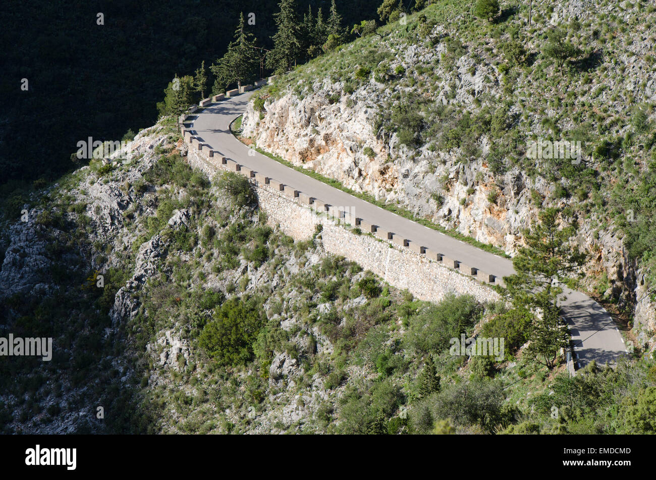 Pavimentato stretta strada di montagna con basse barriere di pietra a Ojen, Andalusia, Spagna. Foto Stock