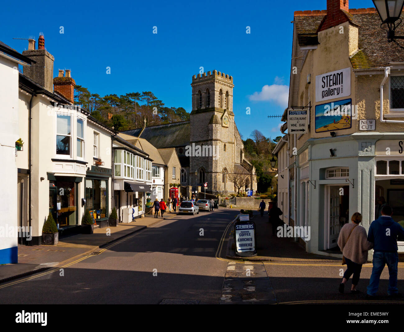 Vista guardando lungo Fore Street nella birra nel sud-est Devon England Regno Unito mostra la chiesa di San Michele in background Foto Stock