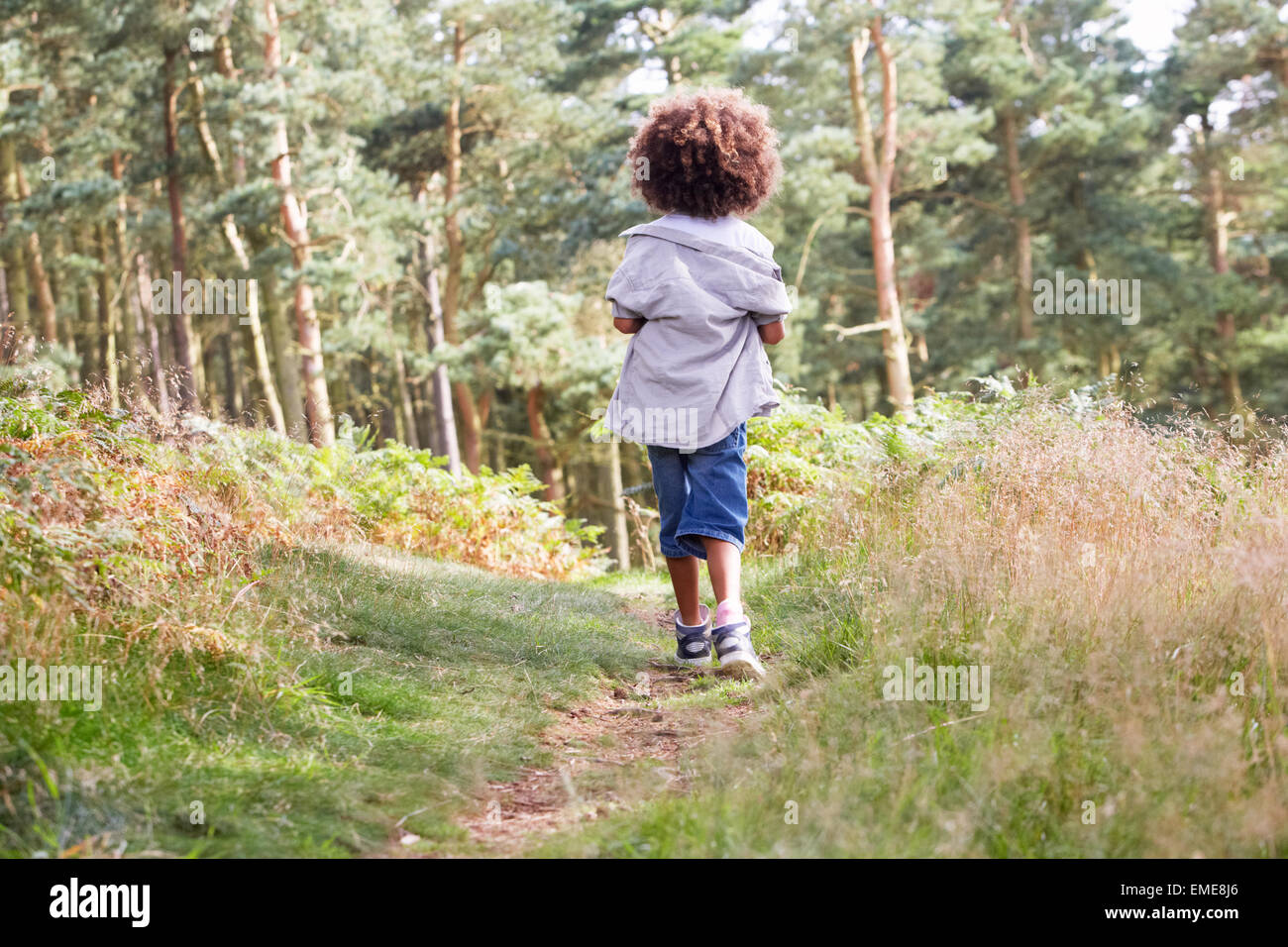 Ragazzo che corre attraverso boschi Foto Stock