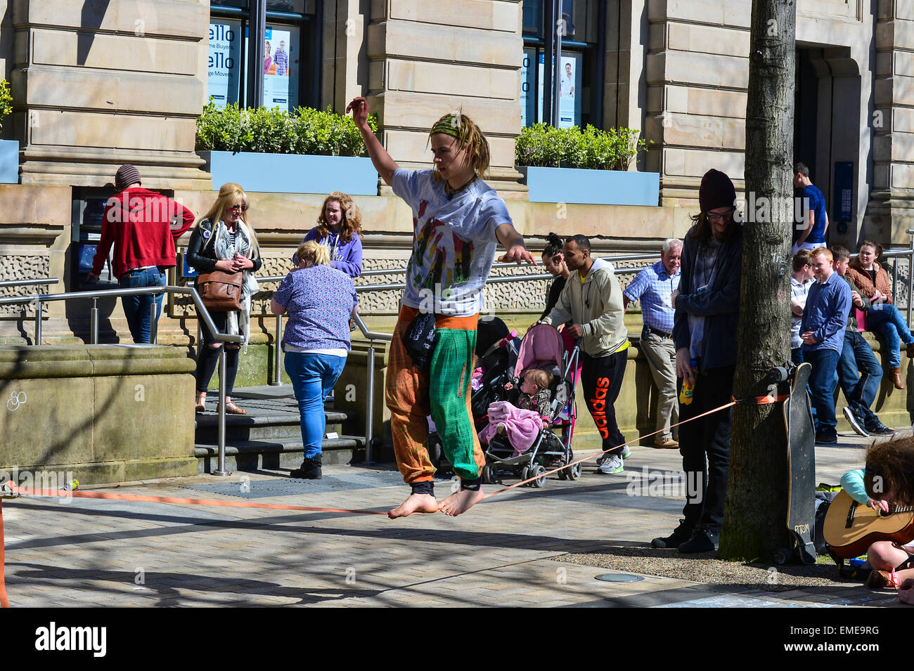 Young street esecutore esegue tightrope agire in Guildhall Square, Londonderry (Derry), Irlanda del Nord Foto Stock