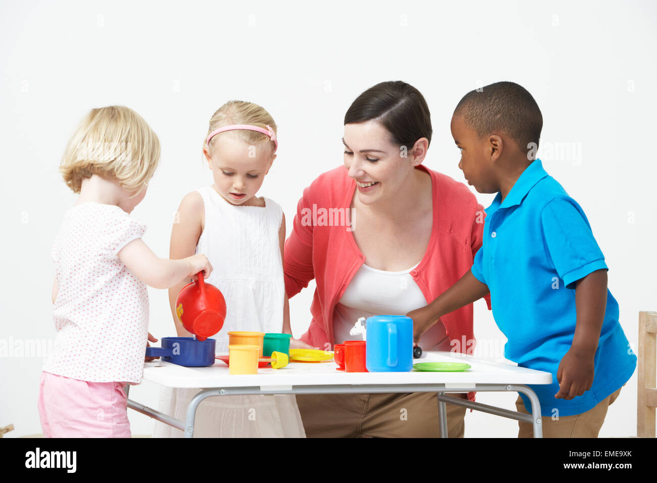 Pre scuola bambini godendo di Tea Party con insegnante Foto Stock