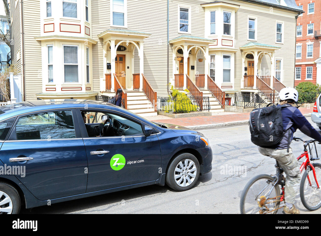 Zipcar, Zip auto nella città di Cambridge street vecchio quartiere passa in bicicletta, Massachusetts, STATI UNITI D'AMERICA. Foto Stock