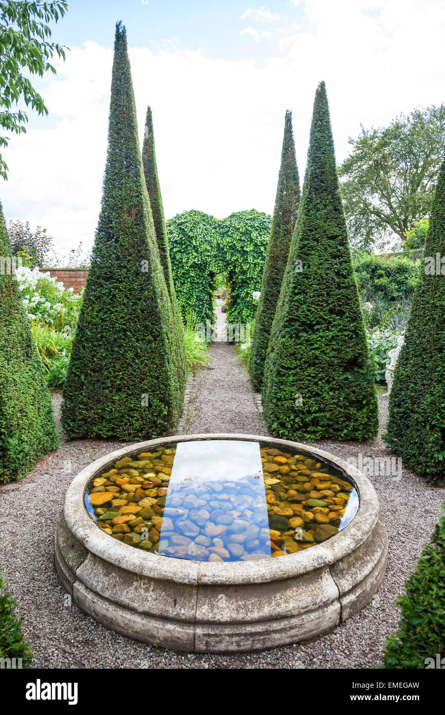 Ritagliato yew guglie e bene a Wollerton Old Hall Giardini Giardino Wollerton Market Drayton Shropshire England Regno Unito Foto Stock