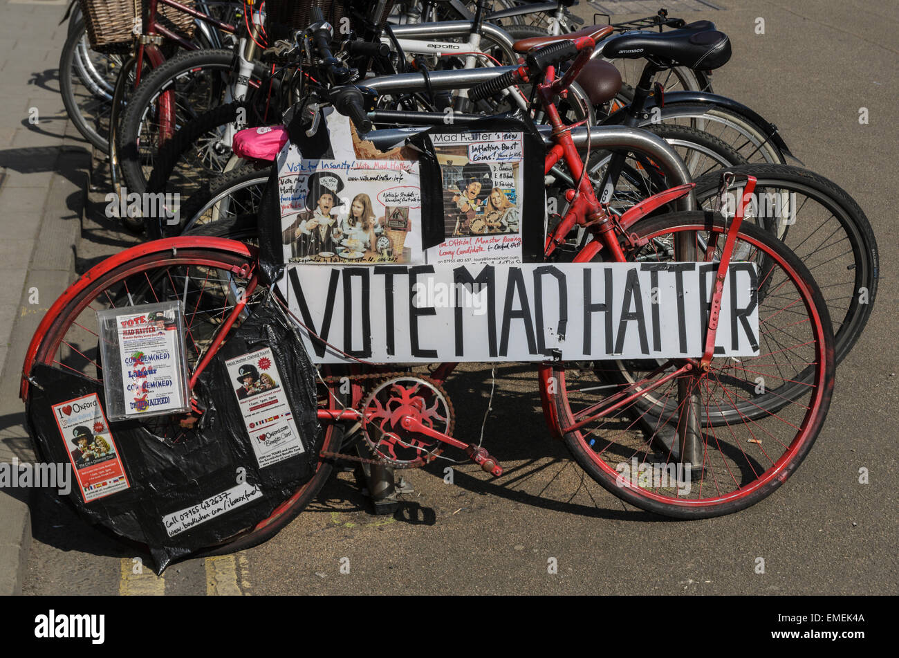 Una bicicletta parcheggiata su Broad Street, Oxford, Regno Unito promuovere il Mad Hatter candidato per Oxford est in U.K. Le elezioni generali del 2015. Il Mad Hatter è vero nome è Alasdair de Voil, un imprenditore locale in piedi contro l'operatore storico p.f. Andrew Smith (Manodopera) in Oxford East Ward. Foto Stock