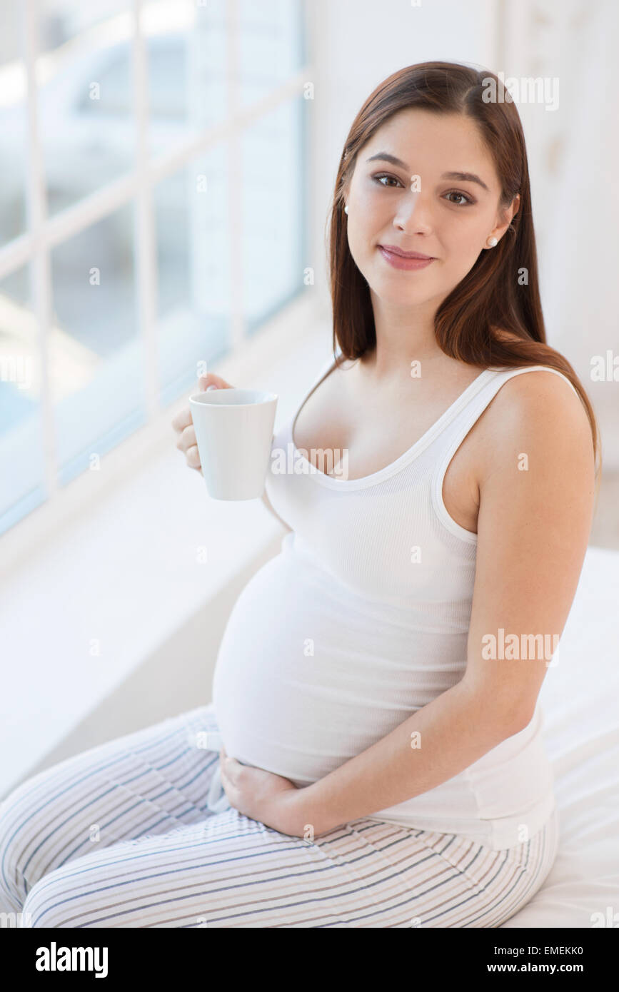 Donna incinta tenendo una tazza di tè Foto Stock