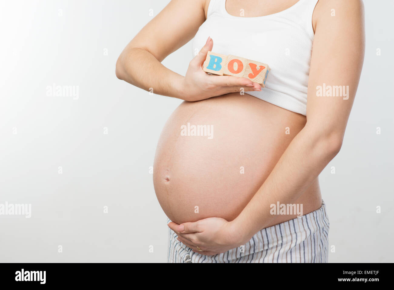 Close up foto di donna incinta pancia e cubi di legno Foto Stock