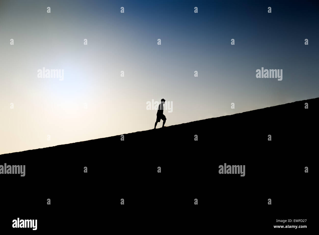 Silhouette di un uomo in salita Foto Stock