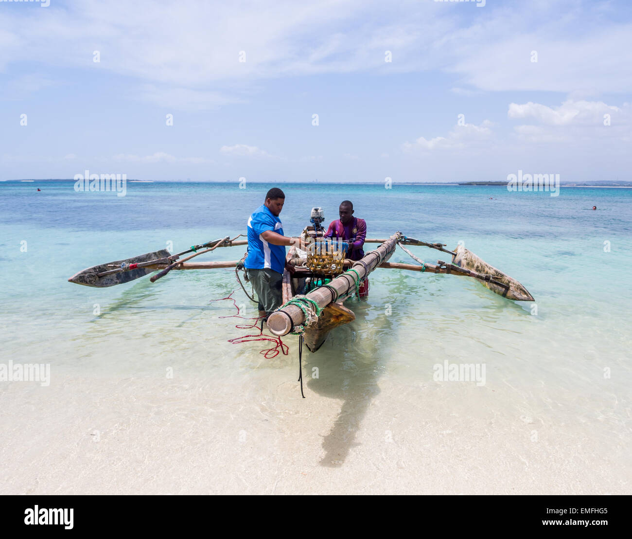 Due pescatori con una barca di legno tradizionale e di pesce sulla spiaggia di Isola Mbudya in Tanzania, Africa. Foto Stock