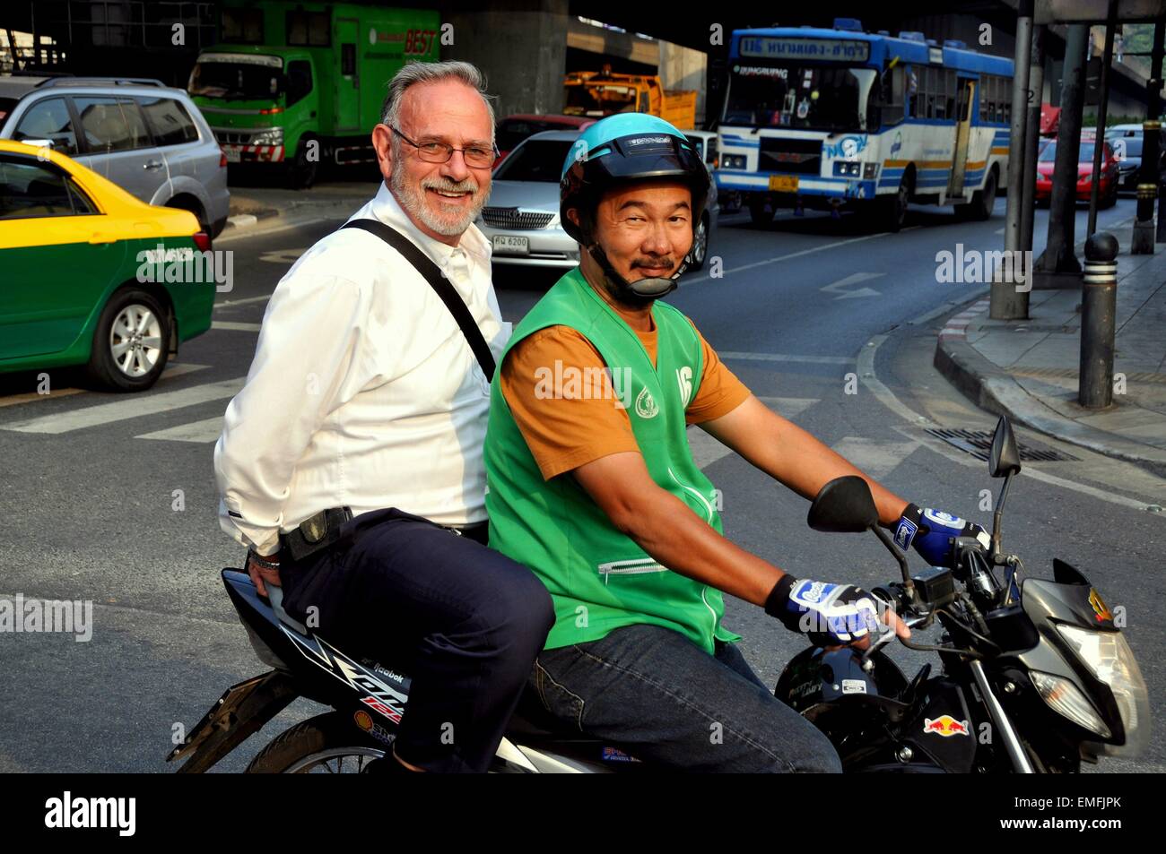 Bangkok, Thailandia: Thai motociclo taxi driver con un 'farang' (straniero) il passeggero su occupato Charoen Krung Road Foto Stock