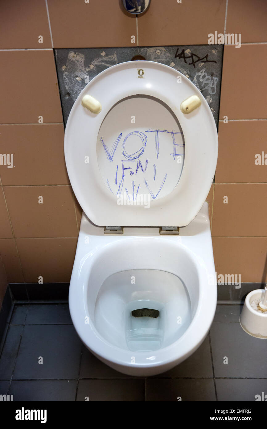 Graffiti su un sedile di gabinetto circa il voto contro la Far-Right Front National Party fn in un pubblico sala di riposo a Parigi, Francia Foto Stock