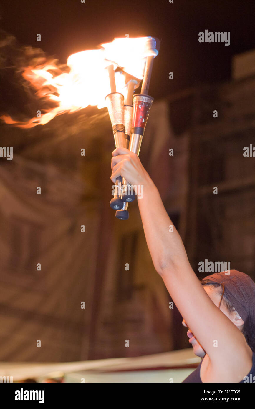 Street performer detiene torchs illuminato durante la coltura Almossasa Festival in Badajoz, Spagna Foto Stock