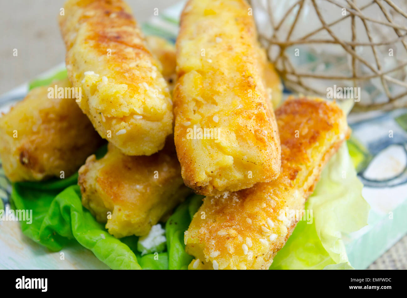 Home cotta torta di sesamo su un tagliere decorato con insalata verde Foto Stock