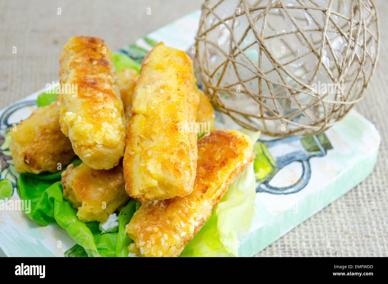 Home cotta torta di sesamo su un tagliere decorato con insalata verde Foto Stock