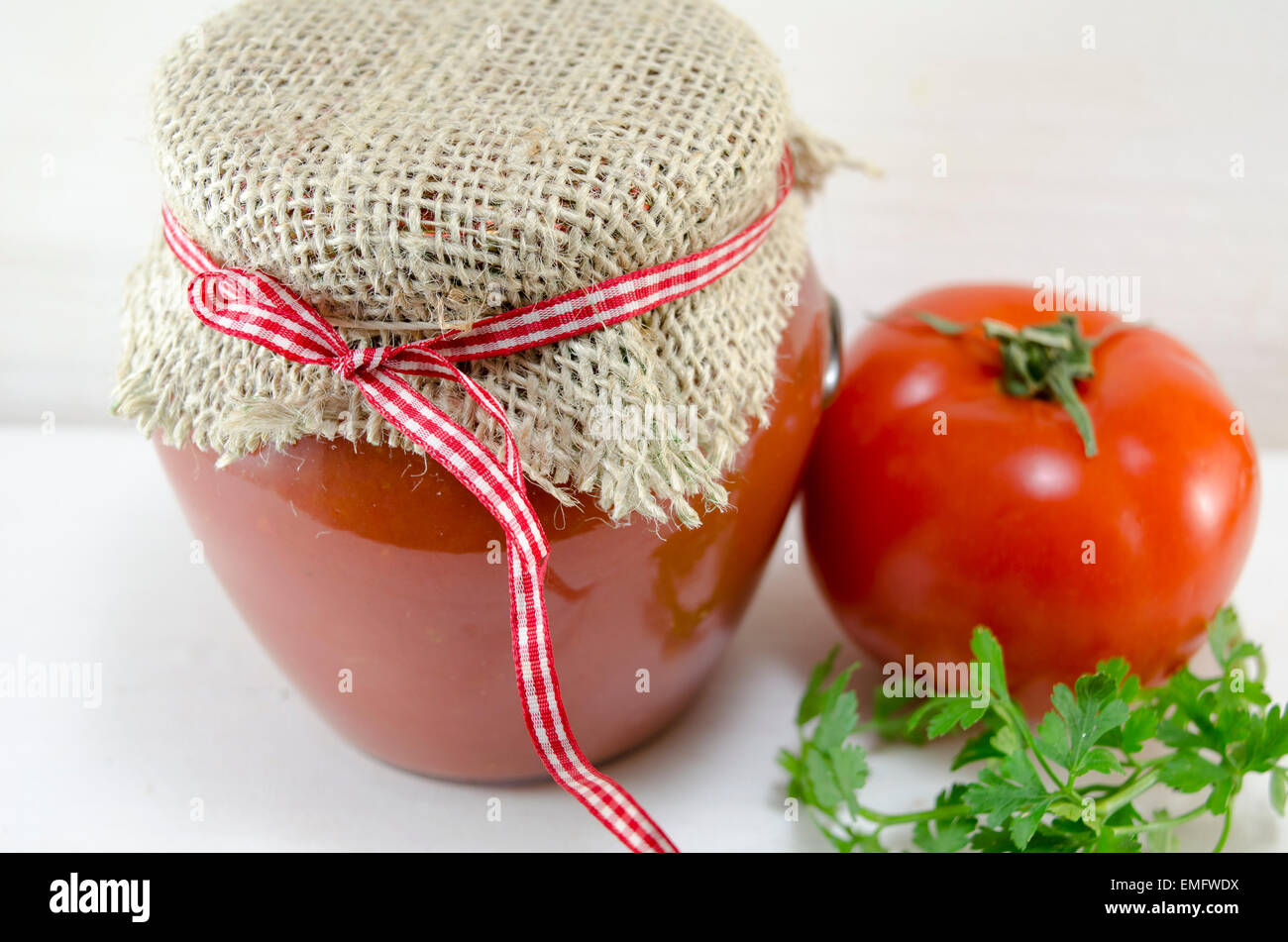 Il vasetto di vetro di ketchup fatta in casa e il pomodoro fresco e prezzemolo Foto Stock