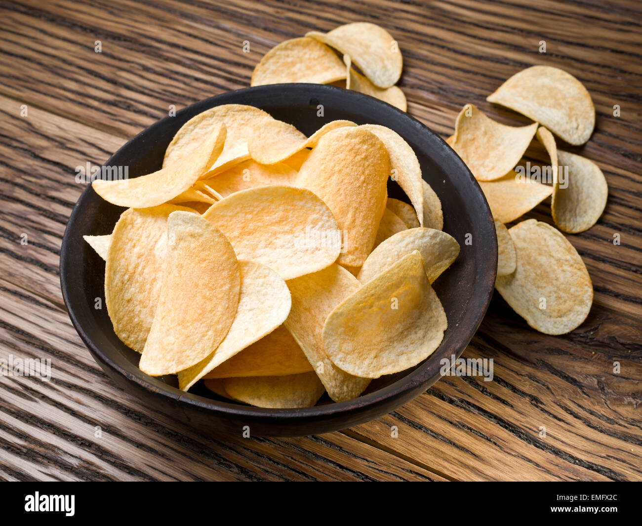 Potato Chips su uno sfondo di legno. Foto Stock