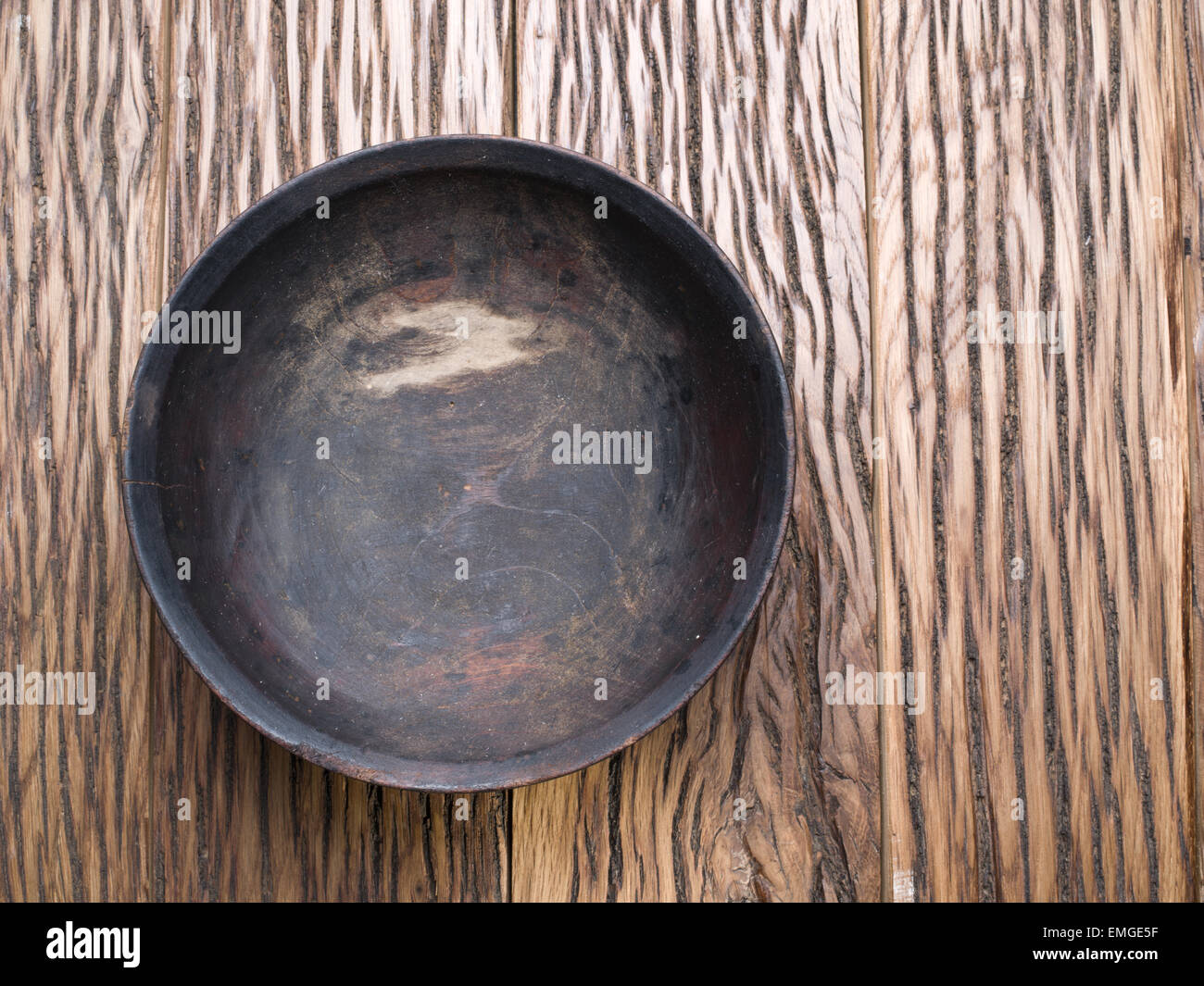 Vecchia ciotola di legno su un tavolo di legno. Foto Stock