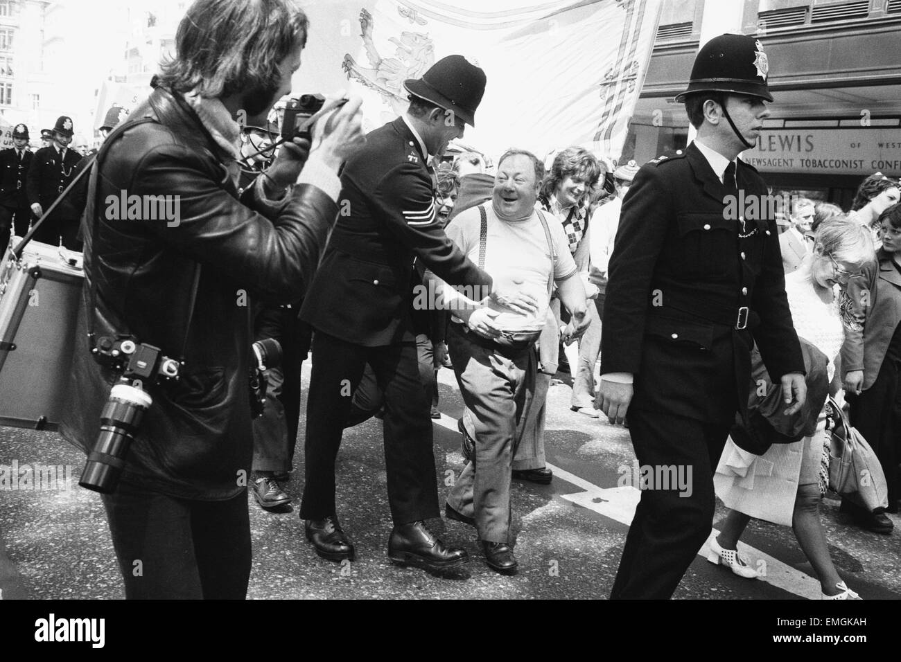 Un uomo è delicatamente restarined da un poliziotto con un colpetto sul suo stomaco come centinaia di lavoratori siderurgici hanno marciato attraverso il Park Lane sul loro modo ad un incontro presso la Central Hall di Westminster. Essi sono stati staging a salvare i nostri posti di lavoro protesta. Il 19 maggio 1975. Foto Stock