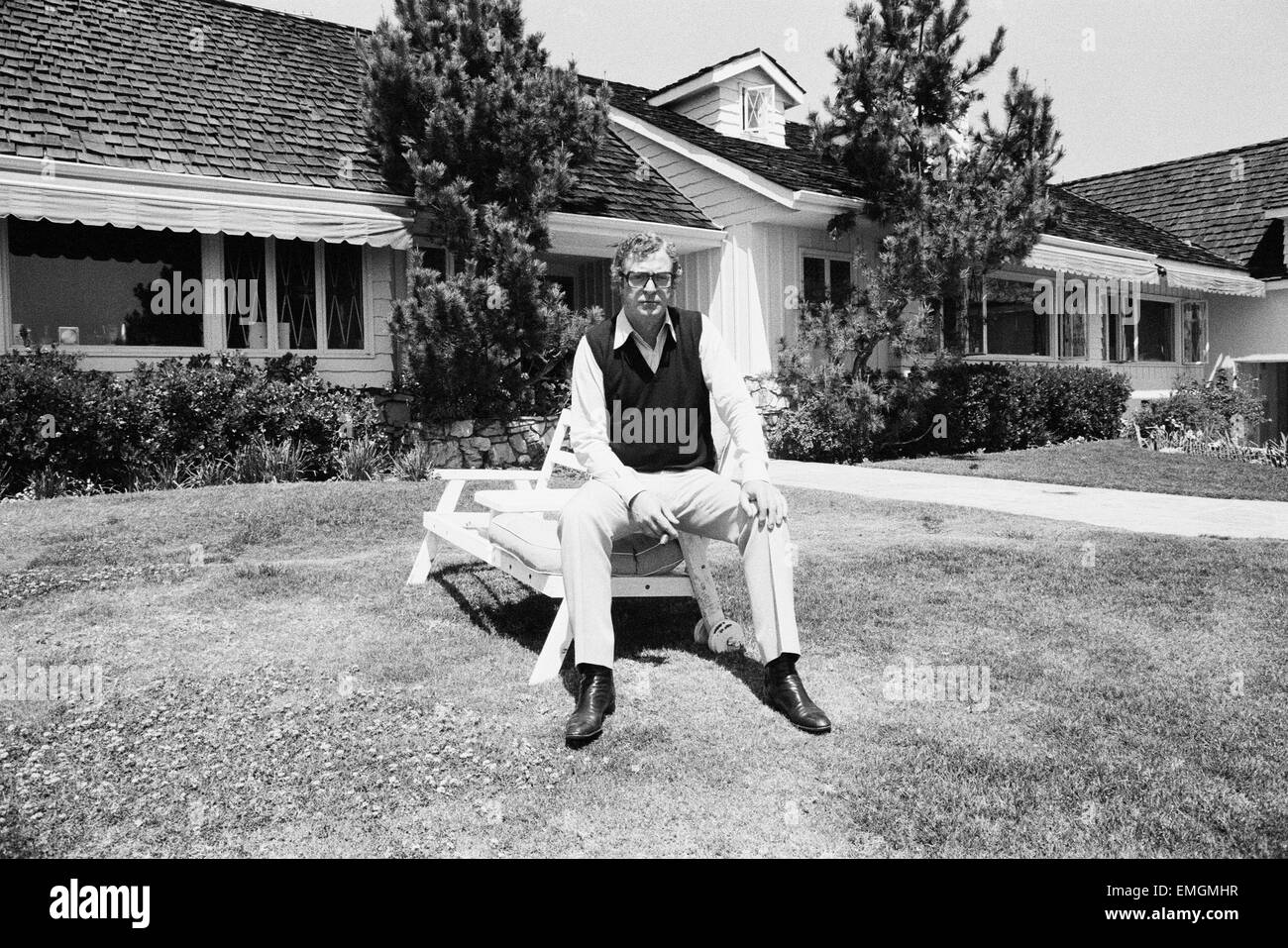 Attore Michael Caine rilassa al di fuori della sua casa in California, Stati Uniti d'America. Il 15 aprile 1984. Foto Stock