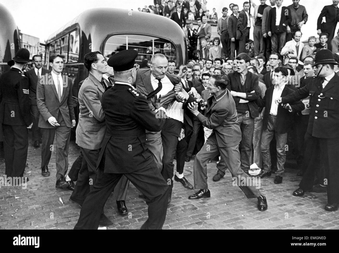 Grande folla riunita in Ridley Road E8 per dimostrare contro l ex leader fascista Sir Oswald Mosley e i membri del suo anti-semita Blackshirt gruppo che aveva previsto un rally in East End di Londra. Mosley e il suo anti-semita Blackshirt sono state assalite e punzonati a terra non appena il suo incontro aperto a Ridley Road, Dalston. La polizia ha chiuso la riunione entro i primi tre minuti e reso 54 arresti uno degli arrestati è stato Sir Oswald figlio di Max. Il 2 agosto 1962 la nostra immagine mostra: Sir Oswald Mosley essendo buttato a terra Foto Stock